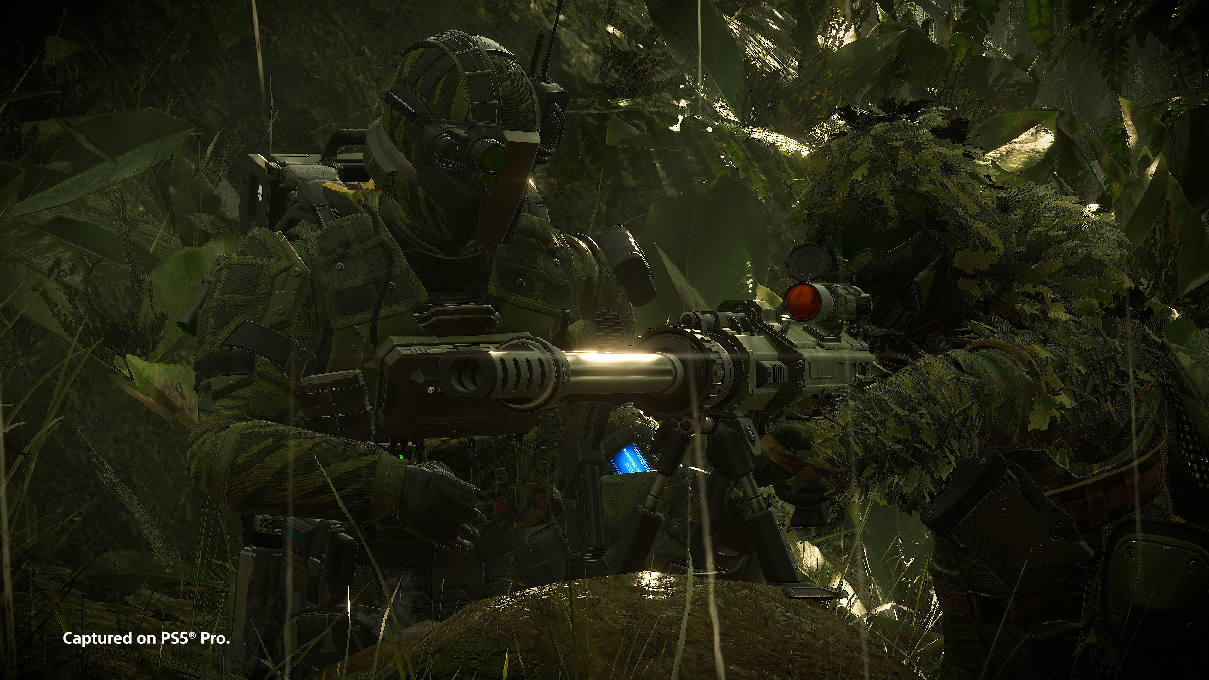 Two Helldivers operate an AMW-20 Apex anti-materiel rifle amid dense green foliage.